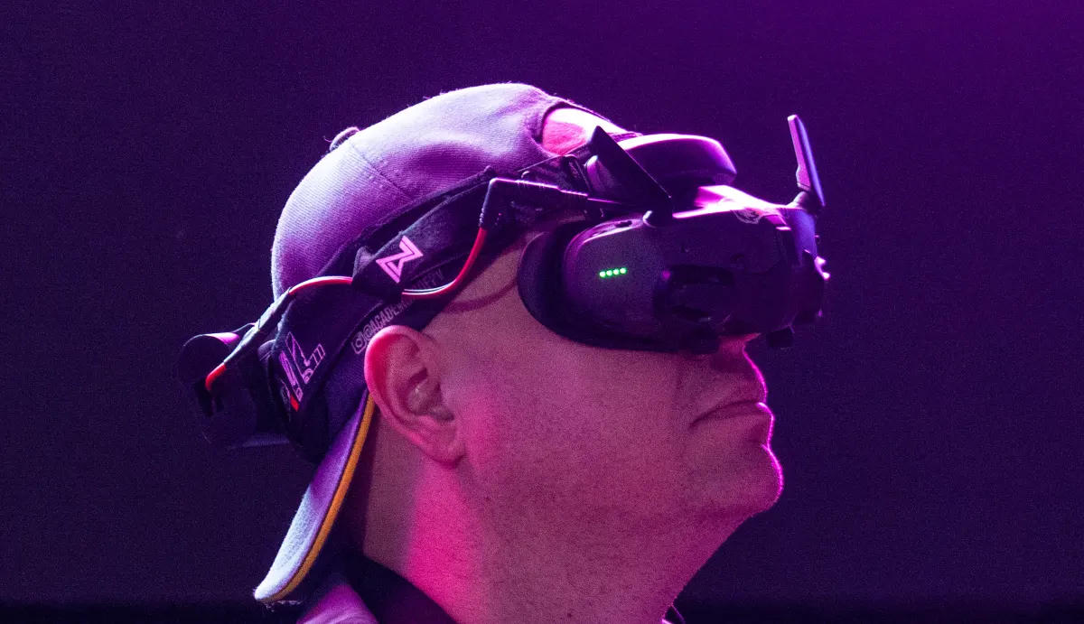 Rodrigo Sclosa pilotando com óculos FPV sob luz de palco